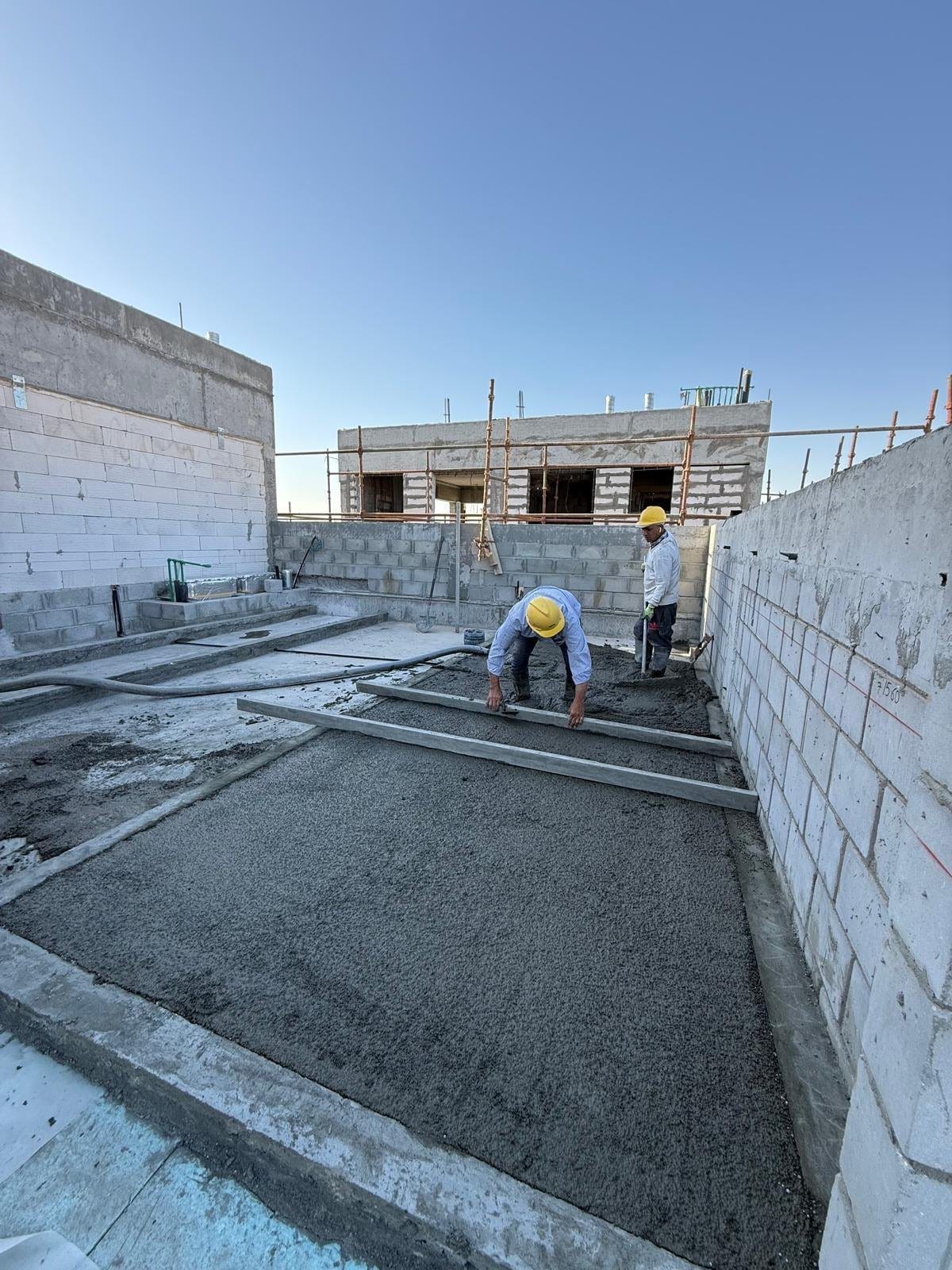 Spreading and screeding the Politerm Blu mix on one of the roofs
